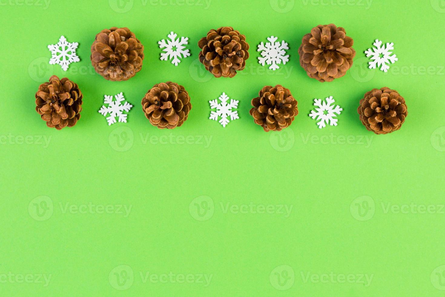 Top view of holiday composition made of pine cones and white snowflakes on colorful background. Winter time and Christmas concept with copy space photo