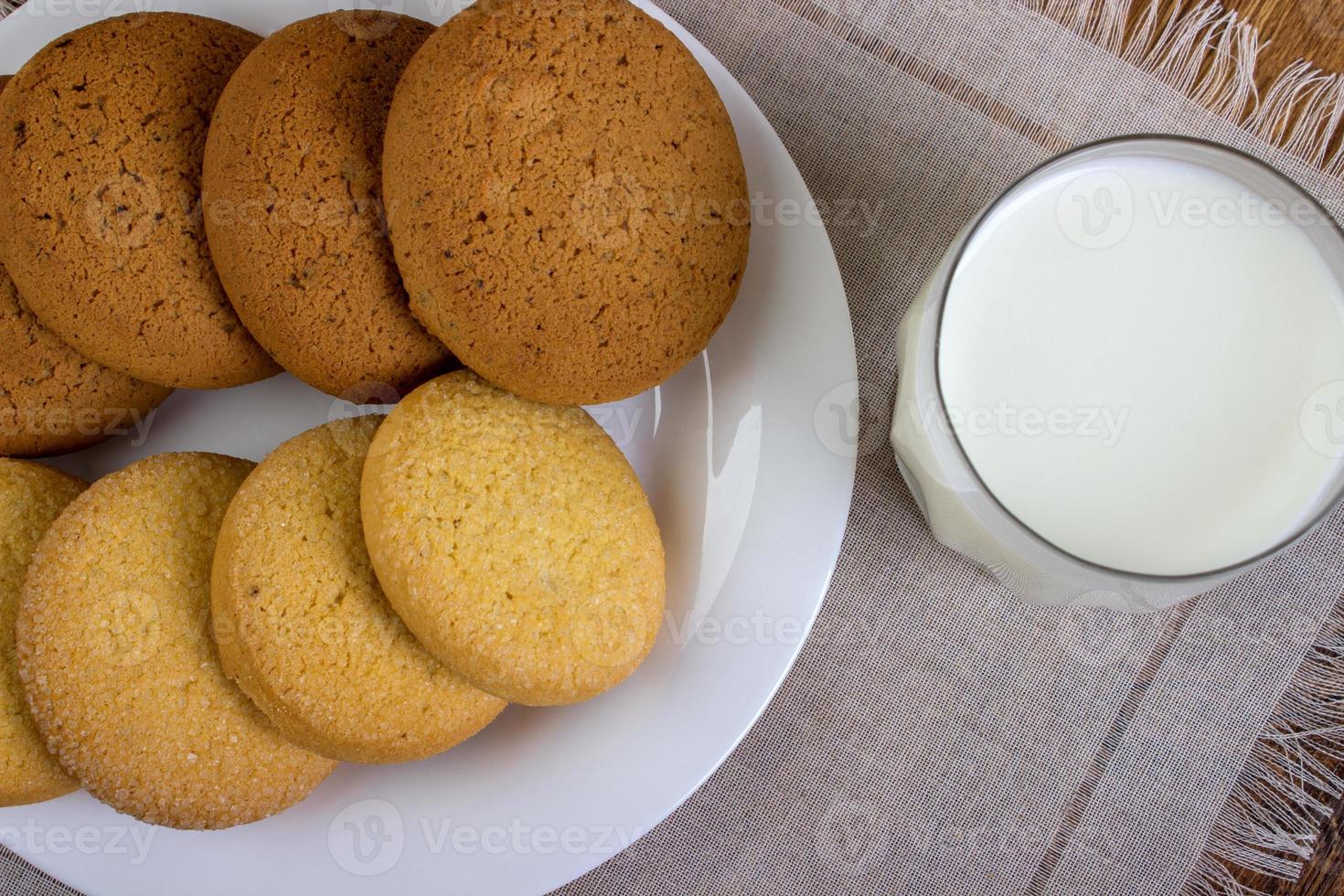 food, junk-food, culinary, baking and eating concept - close up oatmeal cookies and milk glass photo