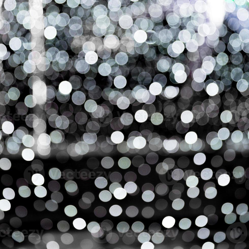 Unfocused abstract white bokeh on black background. defocused and blurred many round light photo