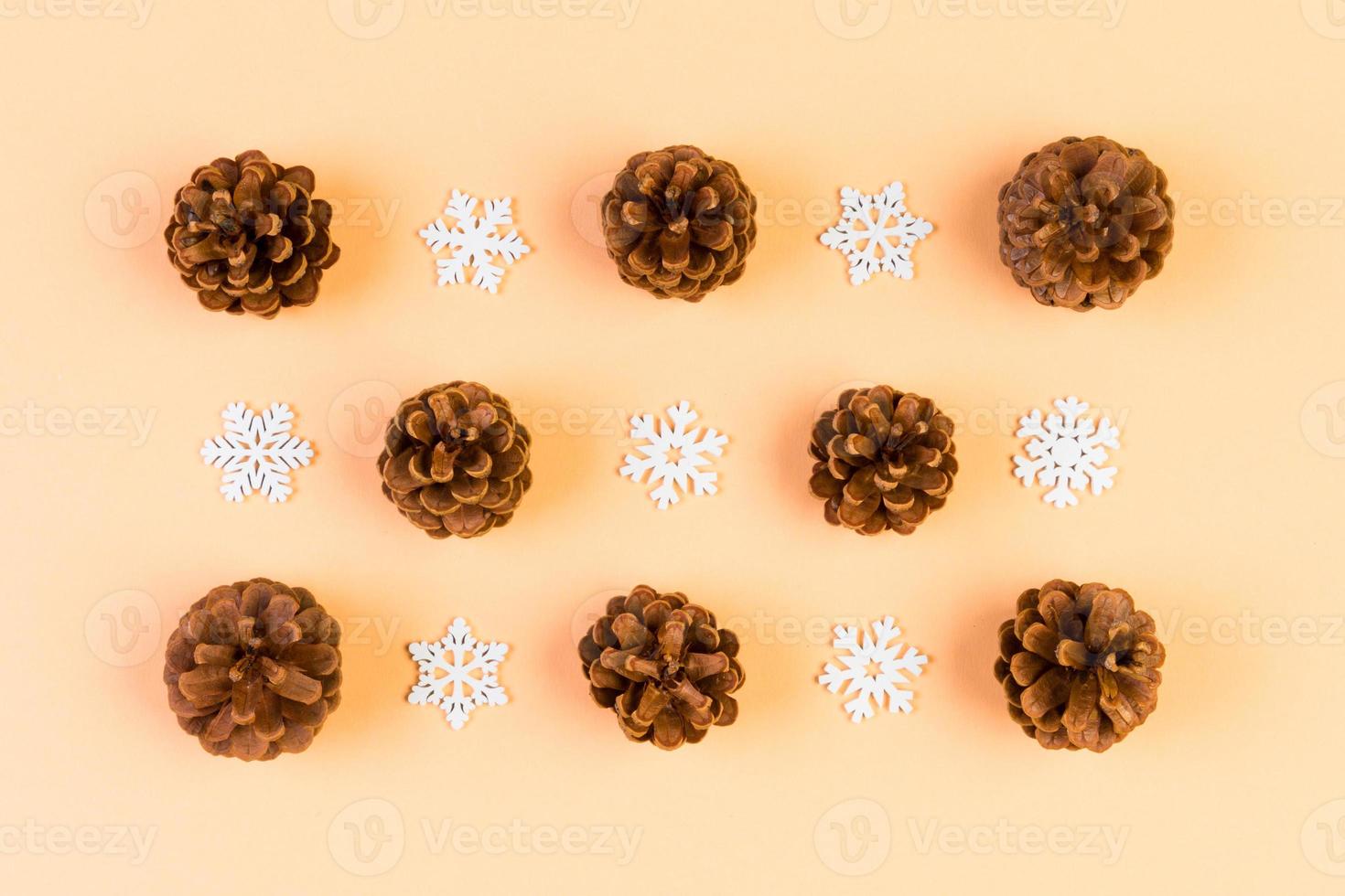 Top view of holiday composition made of pine cones and white snowflakes on colorful background. Winter time and Christmas concept with copy space photo