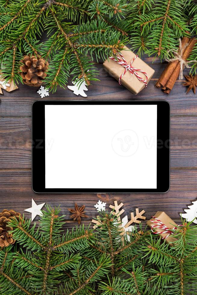 Digital tablet mock up with rustic Christmas wood background decorations for app presentation. top view with copy space photo