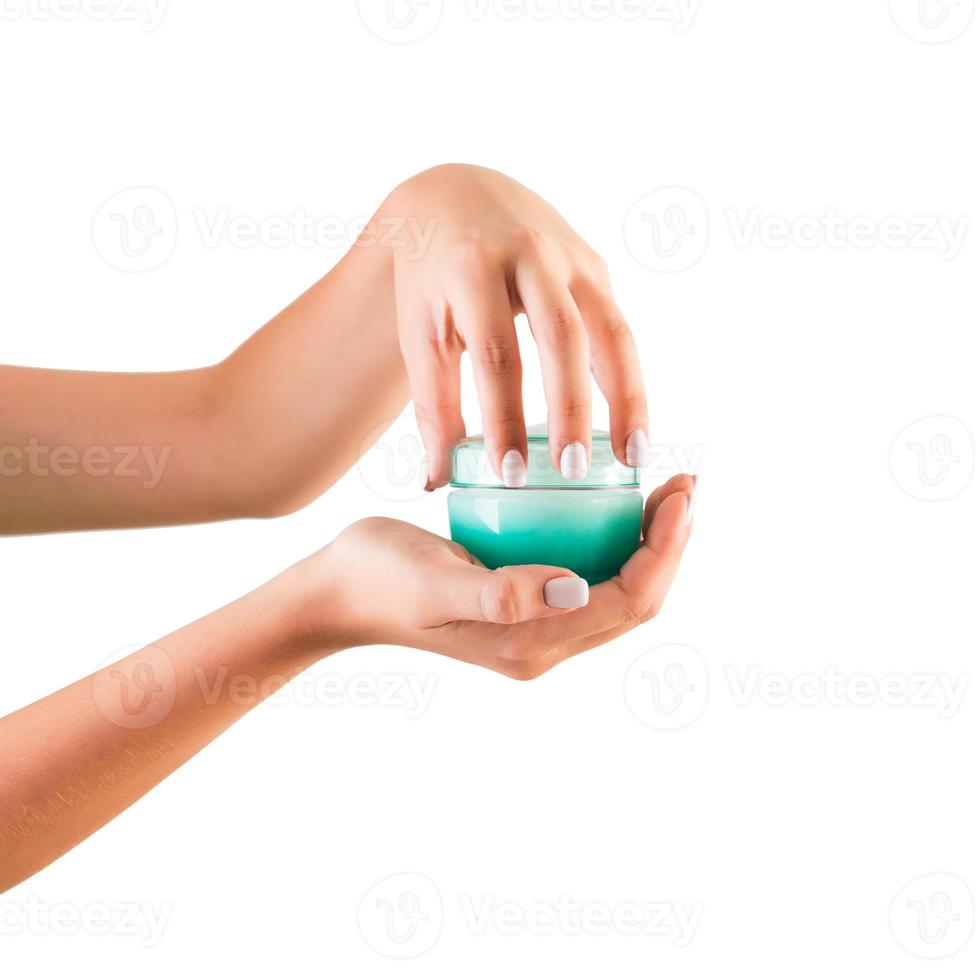 Female hand holding cream bottle of lotion isolated. Girl opening jar cosmetic products on white background photo