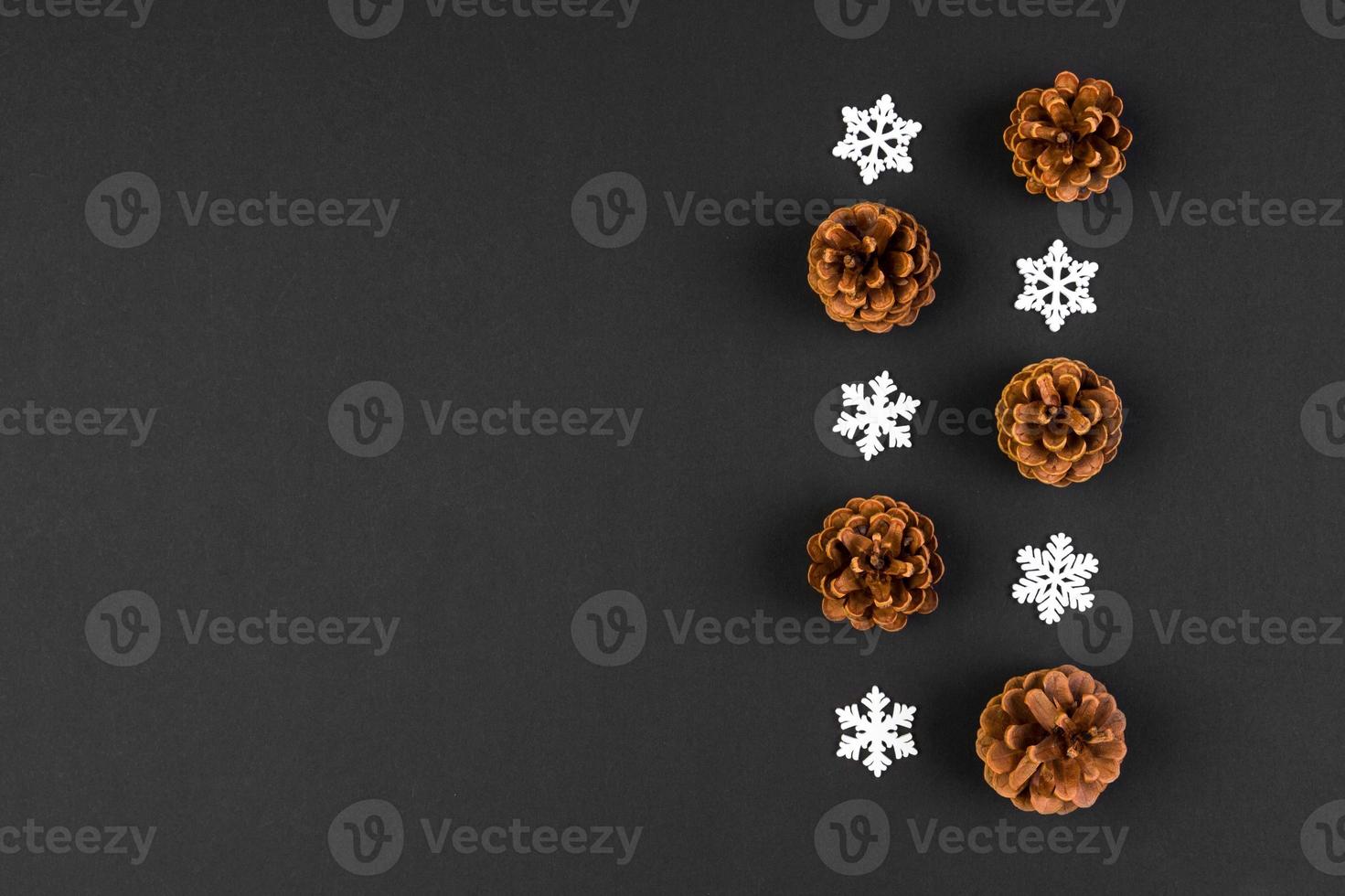 Top view of New Year ornament made of white snowflakes and pine cones on colorful background. Winter holiday concept with empty space for your design photo