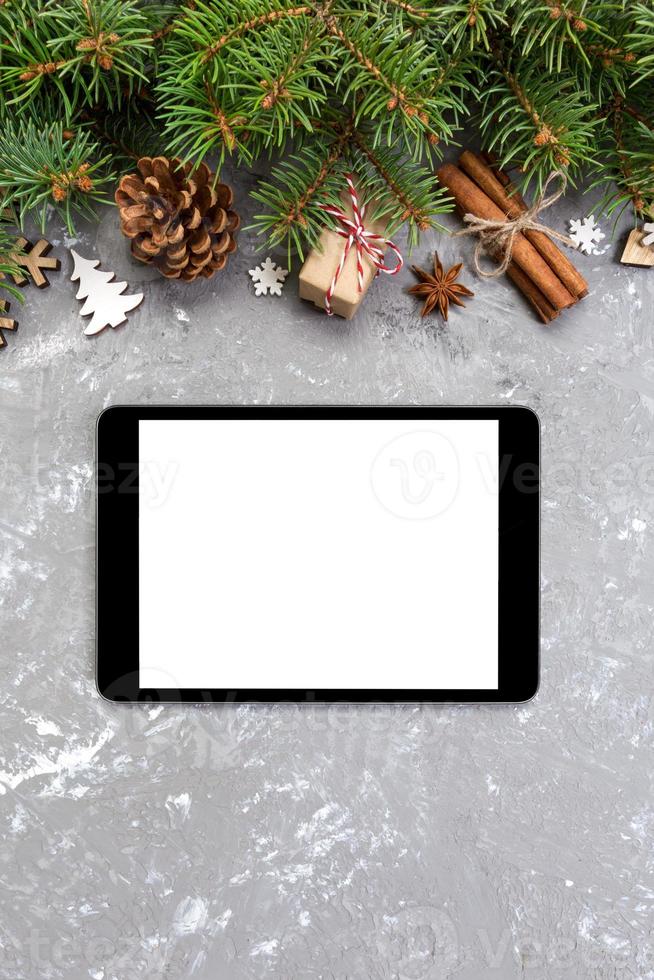 Digital tablet mock up with rustic Christmas gray cement background decorations for app presentation. top view with copy space photo