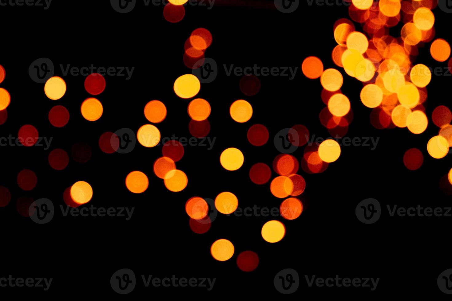 Defocused city gold night bokeh abstract background. blurred many round yellow light on dark background photo