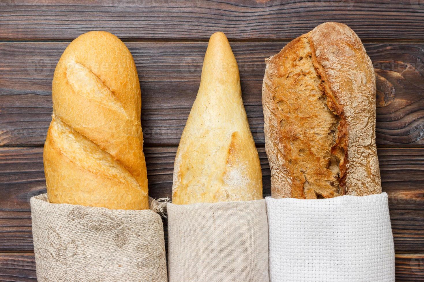 Loaf of bread in a bag european style on a rustic table photo