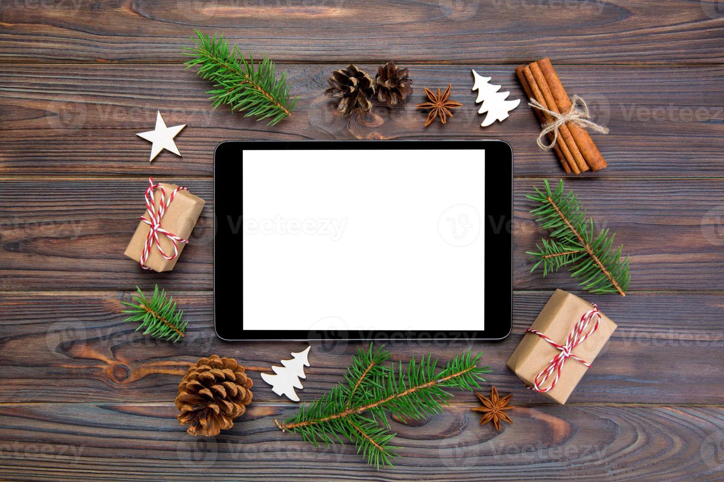 Digital tablet mock up with rustic Christmas wooden background decorations for app presentation. top view with copy space photo