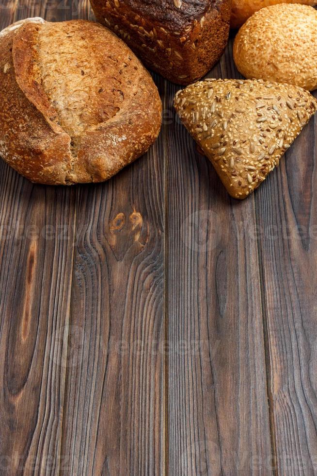 Bakery background, bread assortment on black wooden backdrop. Top view with copy space photo