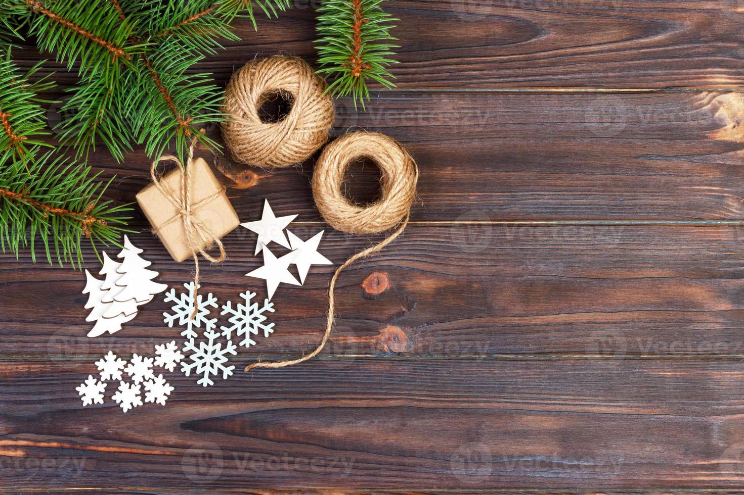 Christmas decoration, gift box in craft paper with twine rope, concept background, top view on wood table surface. Christmas ornaments and presents border with snowflakes and stars photo
