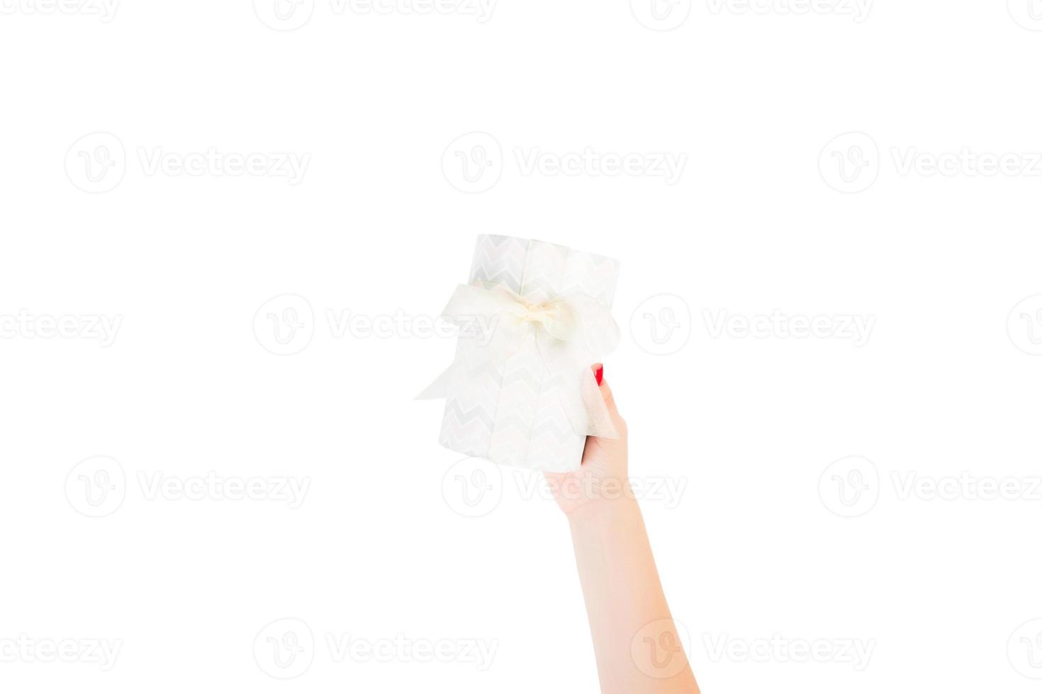 Woman hands give wrapped Christmas or other holiday handmade present in colored paper with yellow ribbon. Isolated on white background, top view. thanksgiving Gift box concept photo