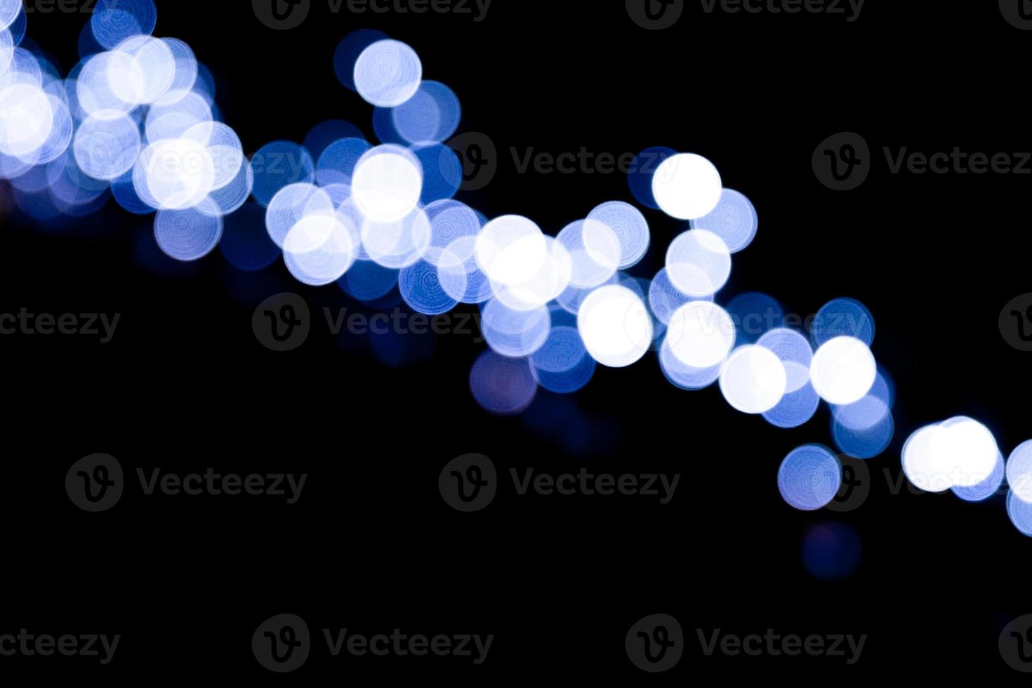 Unfocused abstract colourful bokeh black background. defocused and blurred many round blue light photo