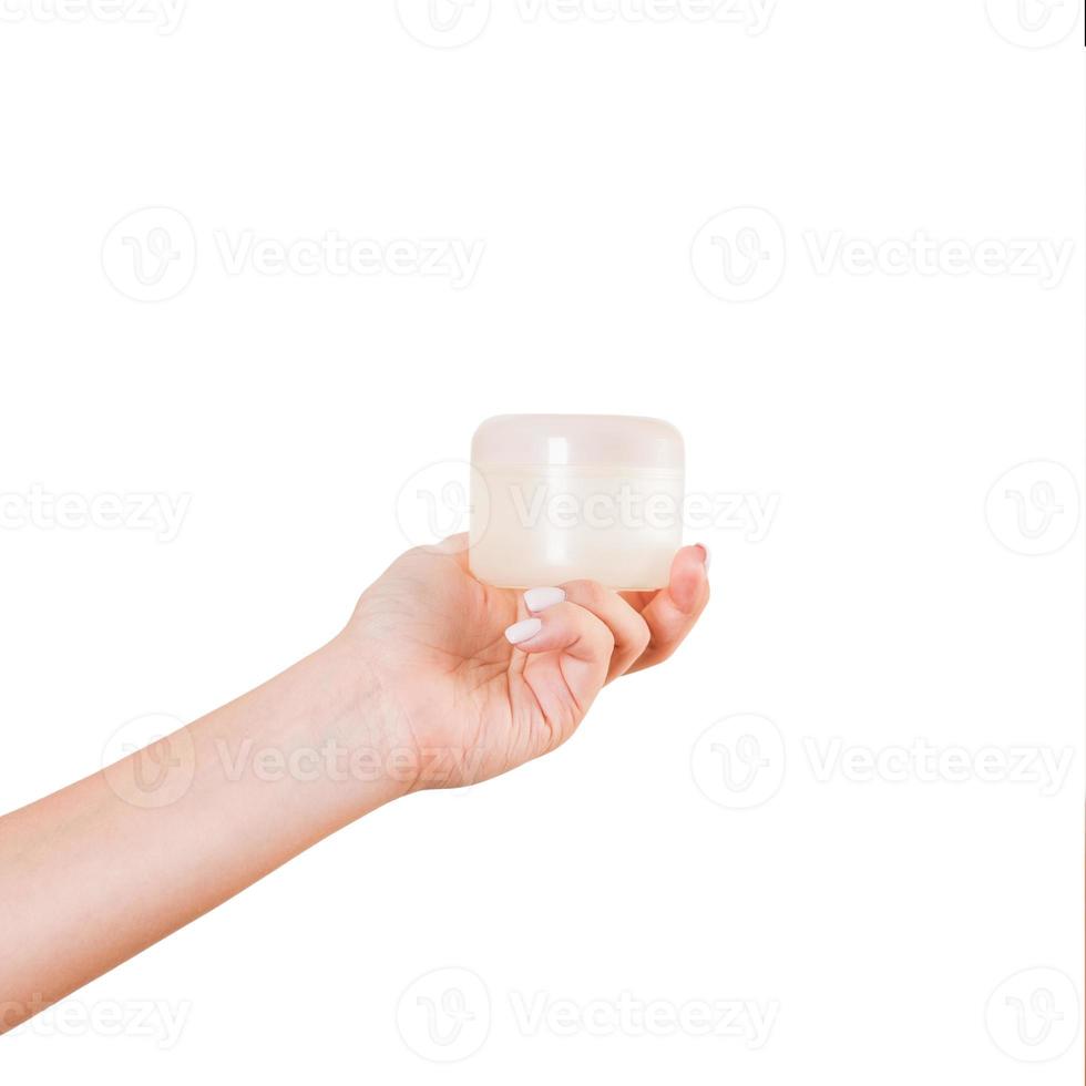 Female hand holding cream bottle of lotion isolated. Girl give jar cosmetic products on white background photo