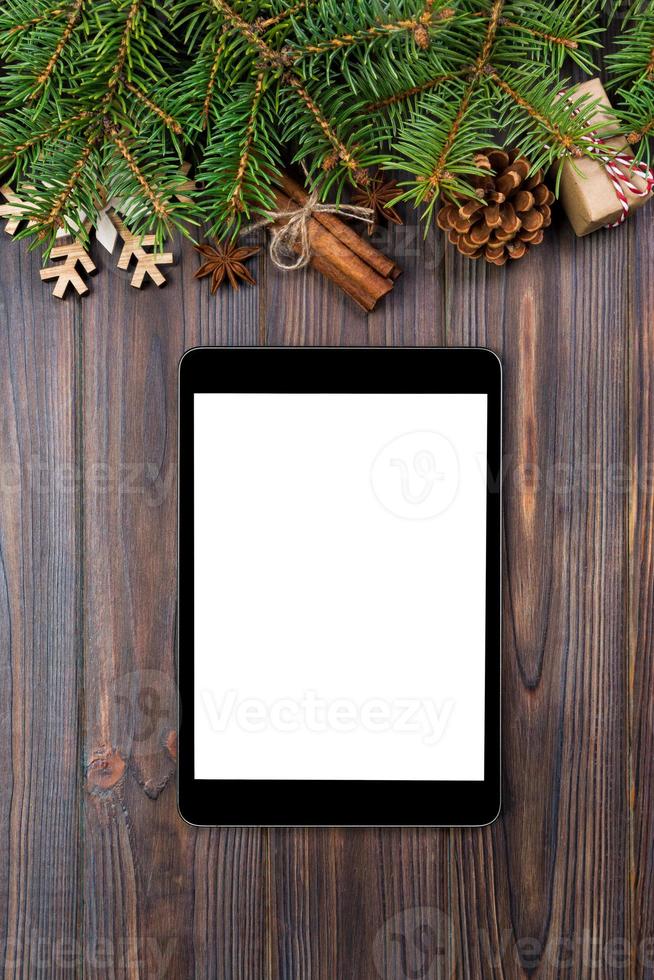 Digital tablet mock up with rustic Christmas wood background decorations for app presentation. top view with copy space photo