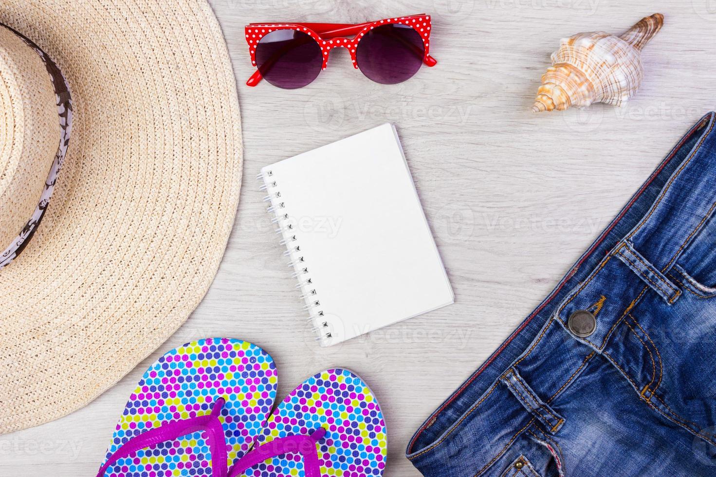 Straw Beach Woman's Hat Sun Glasses Top View Seashell Shorts Flip flops with space for text. photo