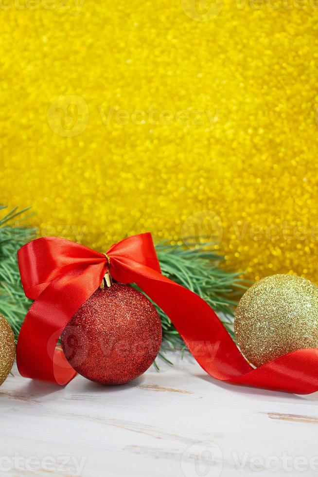 Shiny red and gold balls with bow and twisted ribbon at back of spruce  branch. Yellow blurred glitter vertical background. Christmas, New Year.  Copy space 13625587 Stock Photo at Vecteezy
