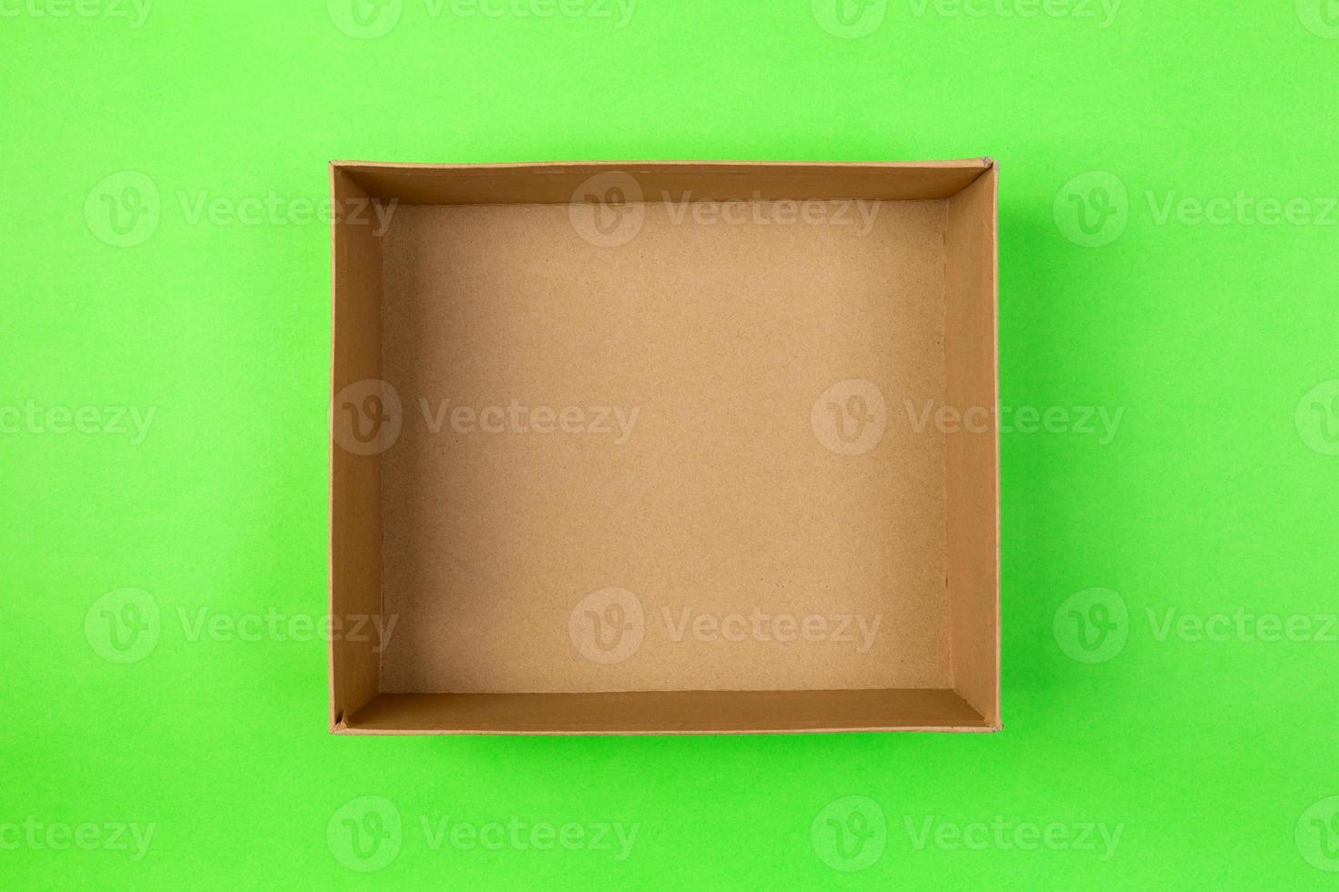 empty cardboard paper box on green background. delivery concept, top view photo