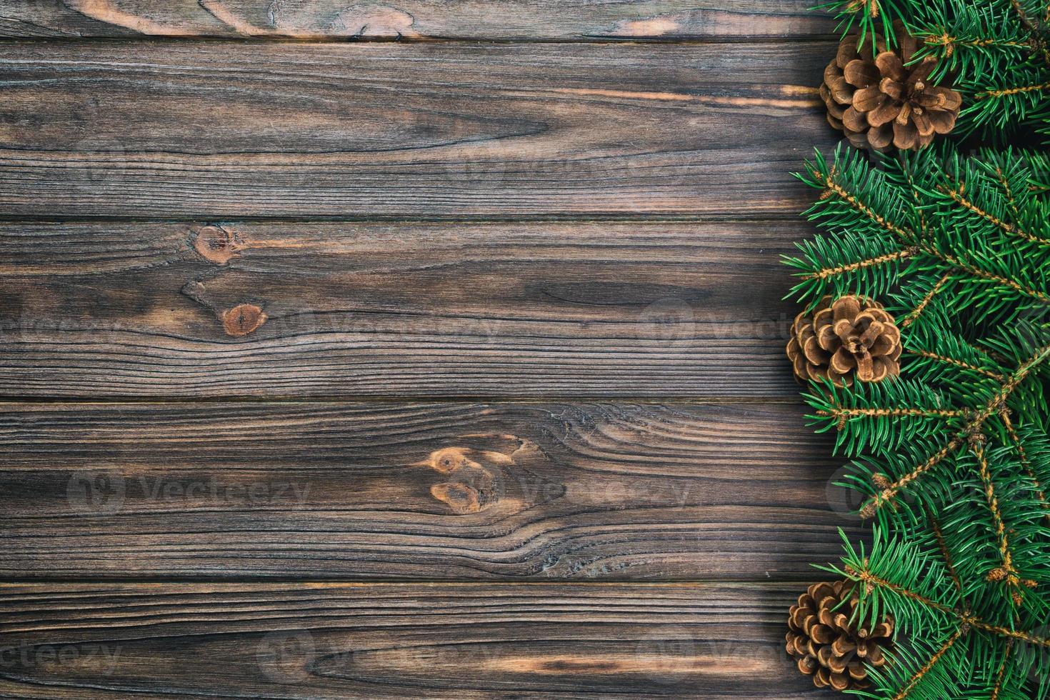 Christmas vintage, toned gray wooden background with fir tree frame and cones copy space. top view empty space for your design photo