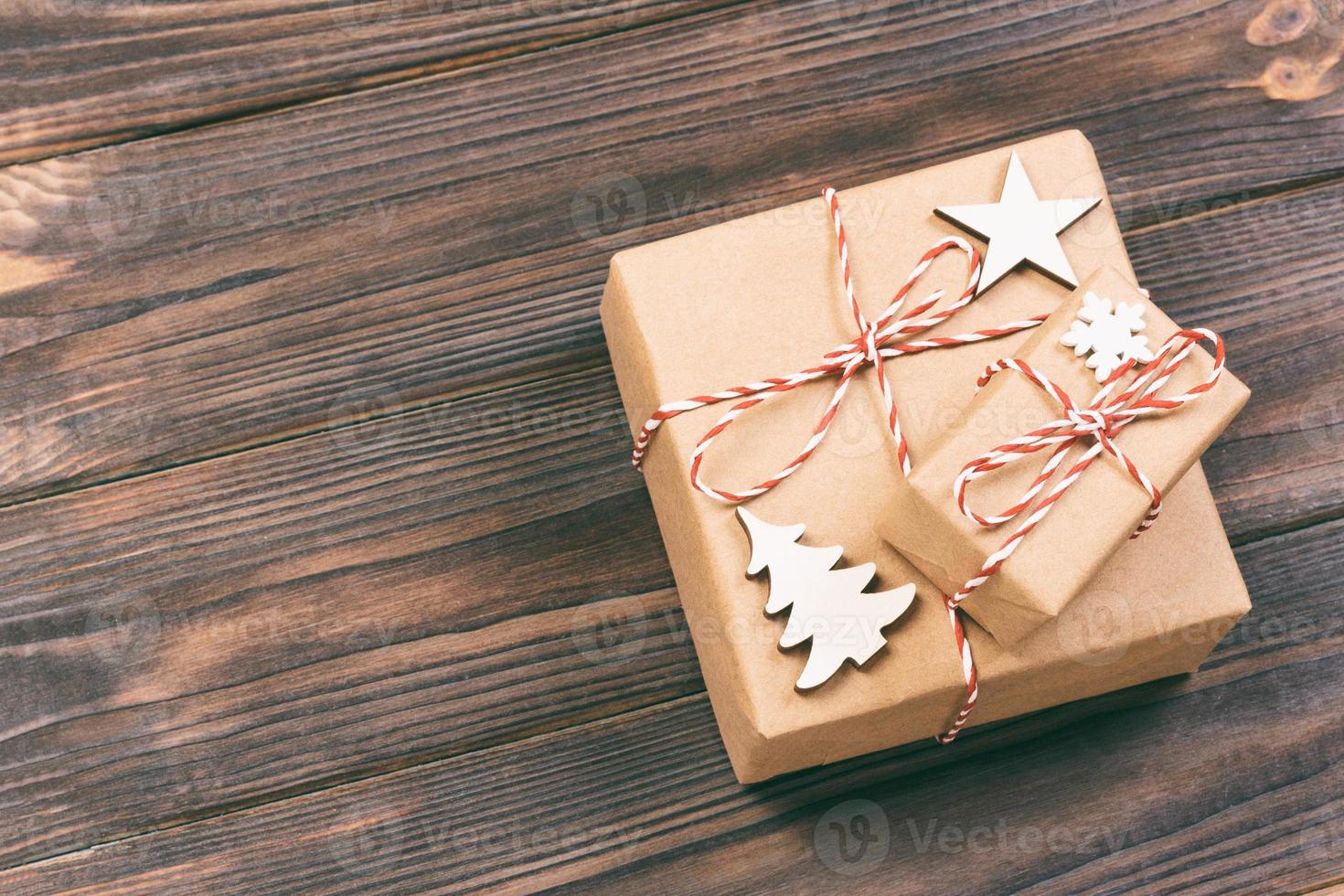 adornos navideños de madera con copos de nieve, estrellas blancas y árboles de navidad sobre un fondo de tablas de madera antiguas negras. fondo para su texto y diseño. tonificado foto