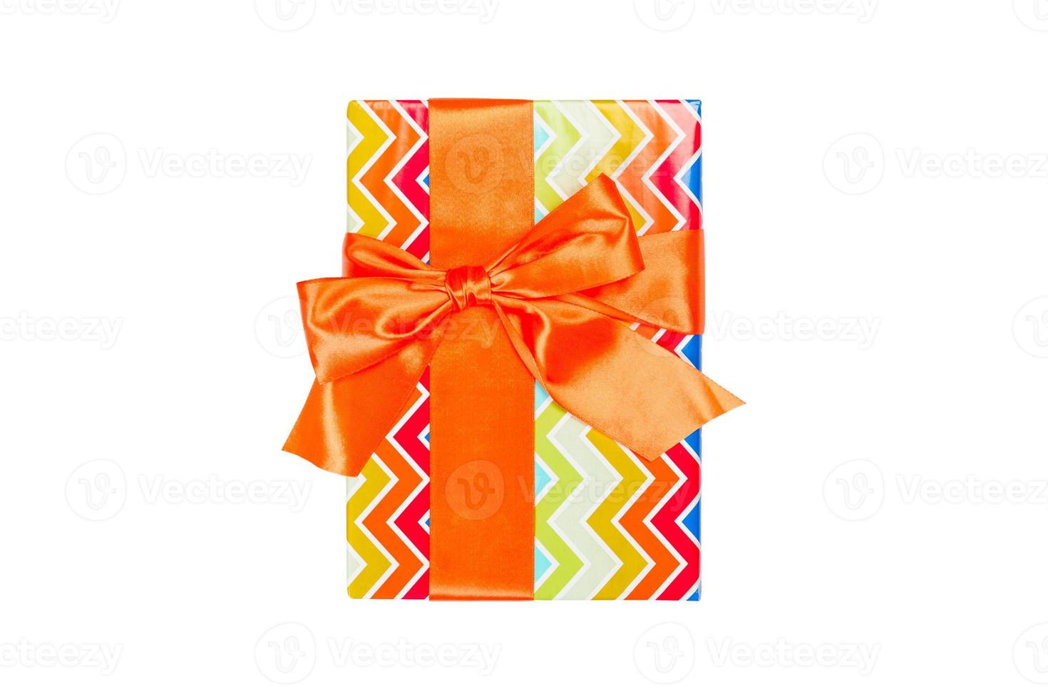 Christmas or other holiday handmade present in colored paper with orange ribbon. Isolated on white background, top view. thanksgiving Gift box concept photo