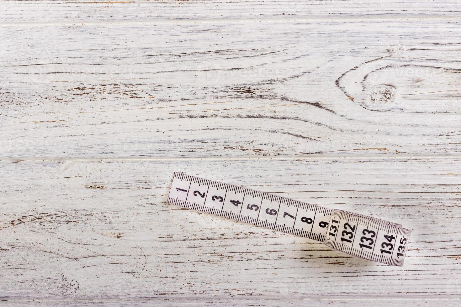 Tailoring Meter White measuring tape on wooden background photo