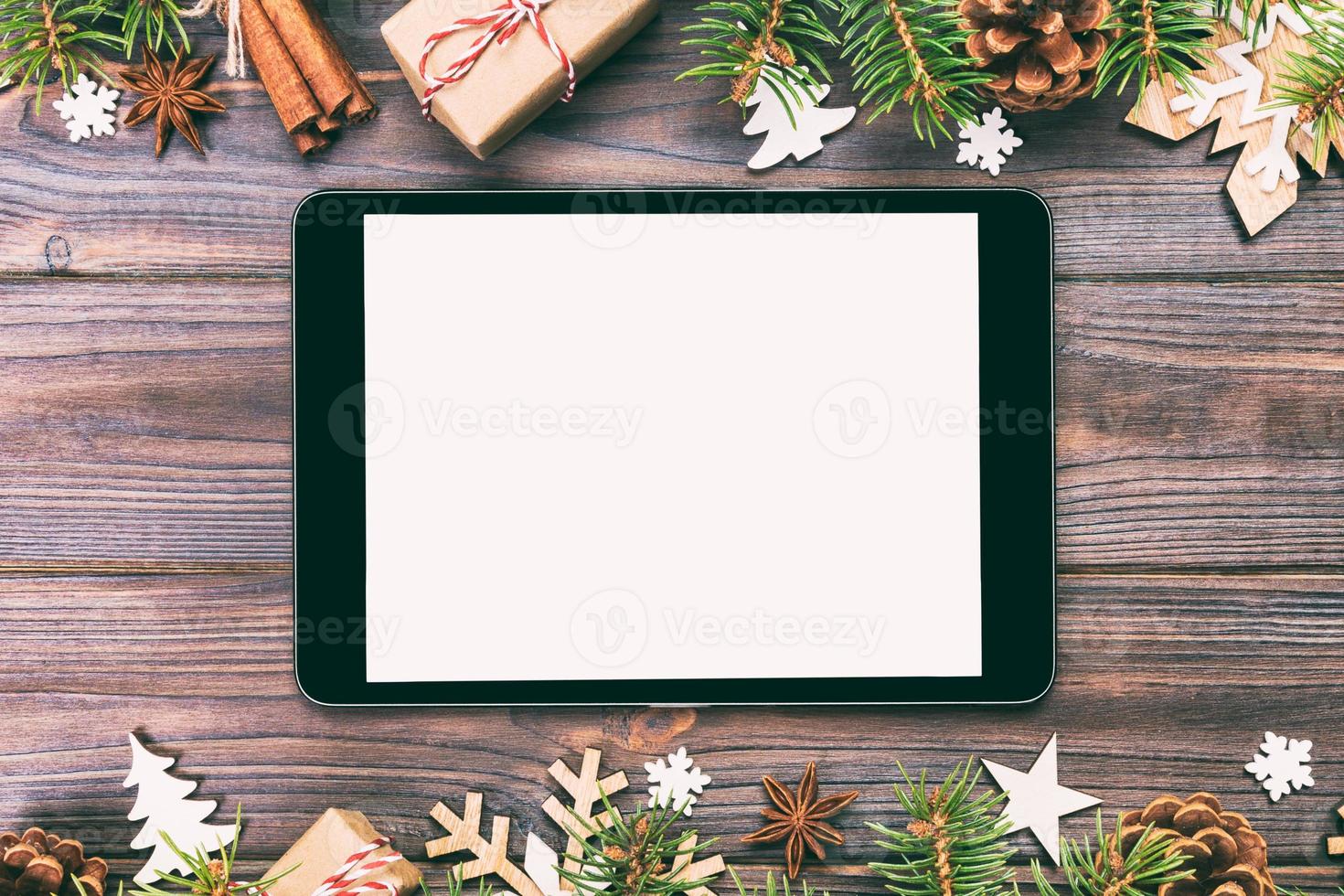Digital tablet mock up with rustic Christmas wood background decorations for app presentation. top view with copy space. Toned photo