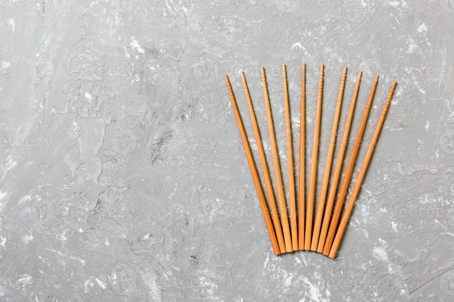 Many bamboo chopsticks on black cement stone background, top view with copy space. a lot of sushi sticks in the form of an ornament photo