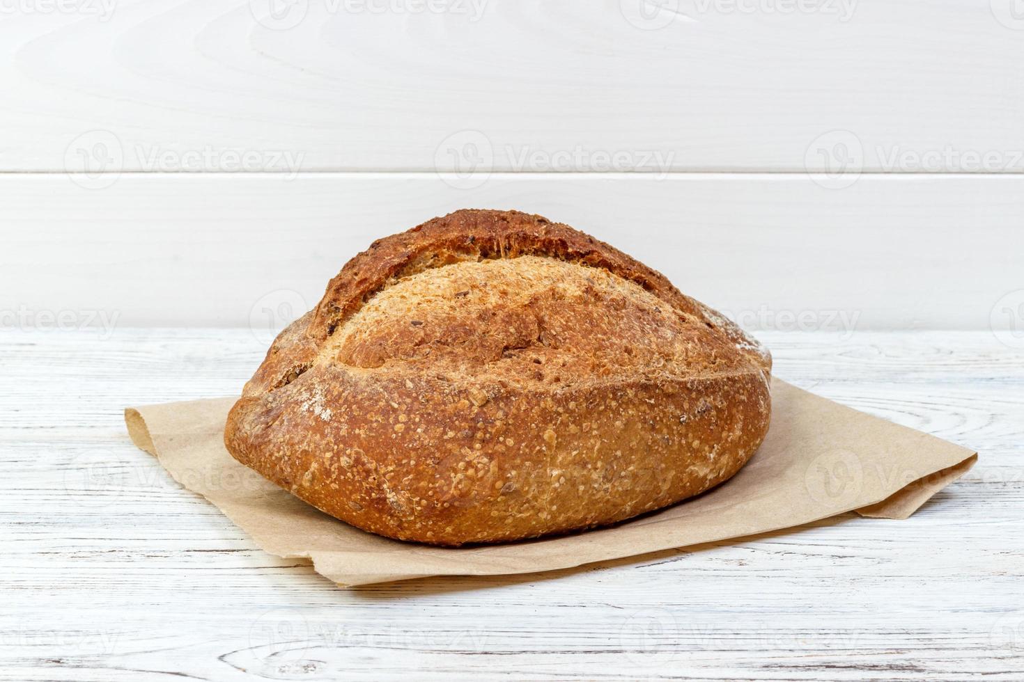 Fresh bread on wooden table. Bread on paper bag photo