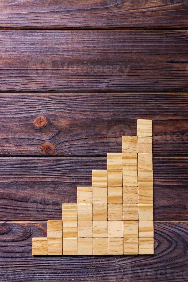 A wooden blocks cube over black wooden textured background with copy space for add word text title. Concept or conceptual Wood block stair or eight steps. Cubic photo
