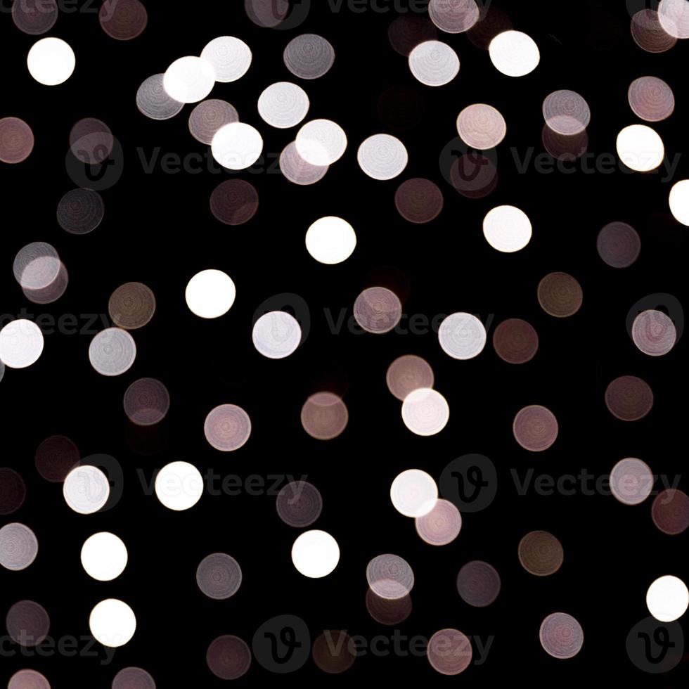 bokeh de luz abstracta como fondo desenfocado y borroso muchas luces redondas sobre fondo negro foto