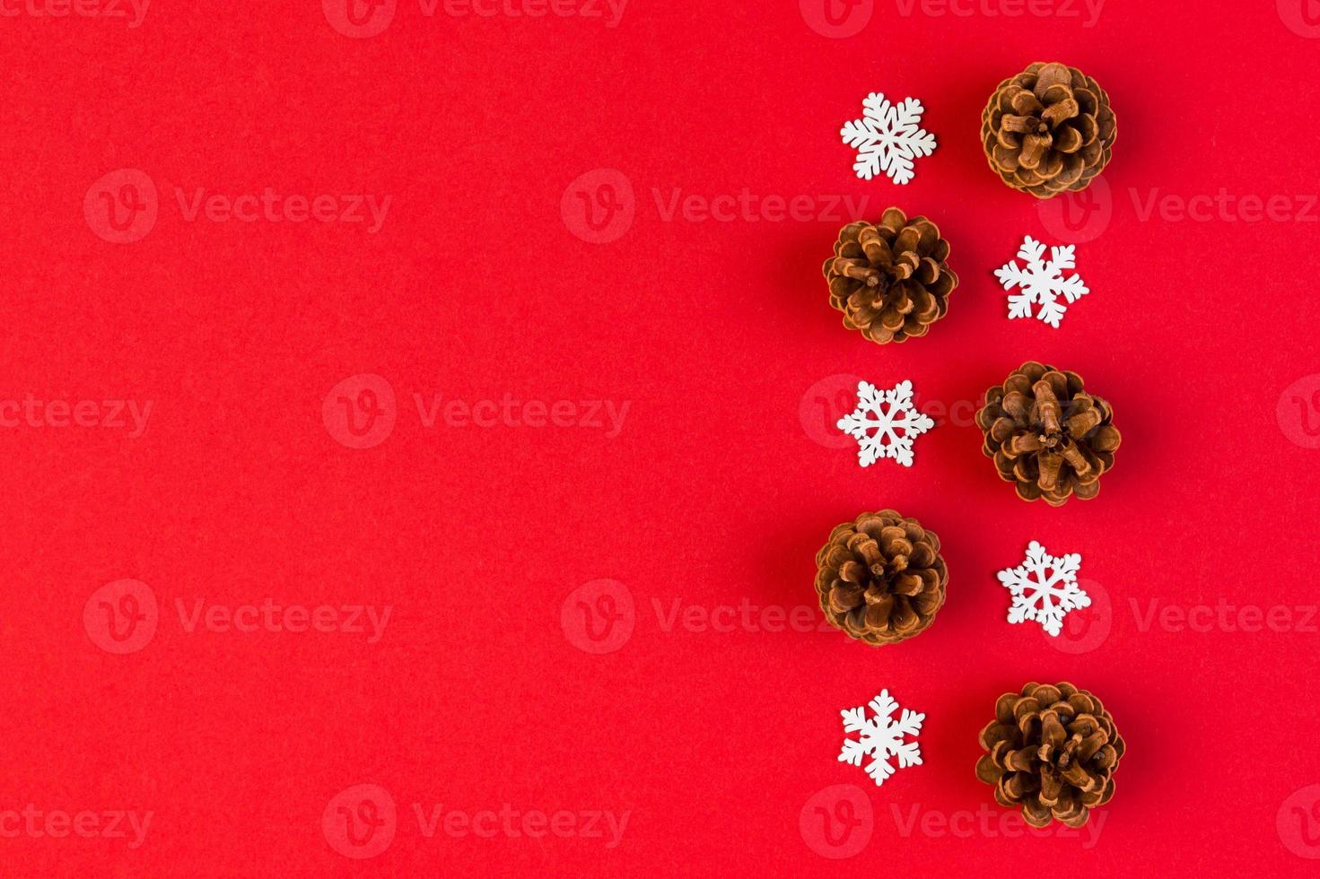 Top view of holiday composition made of pine cones and white snowflakes on colorful background. Winter time and Christmas concept with copy space photo