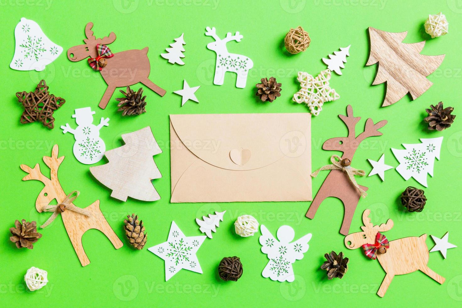 Christmas green background with holiday toys and decorations. Top view of craft envelope. Happy New Year concept photo