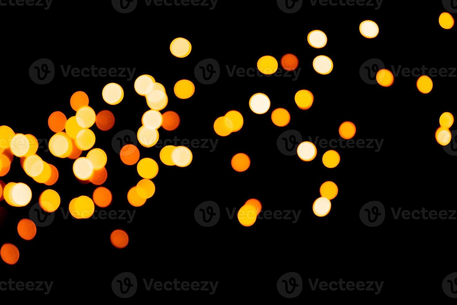 Unfocused abstract gold bokeh on black background. defocused and blurred many round light photo