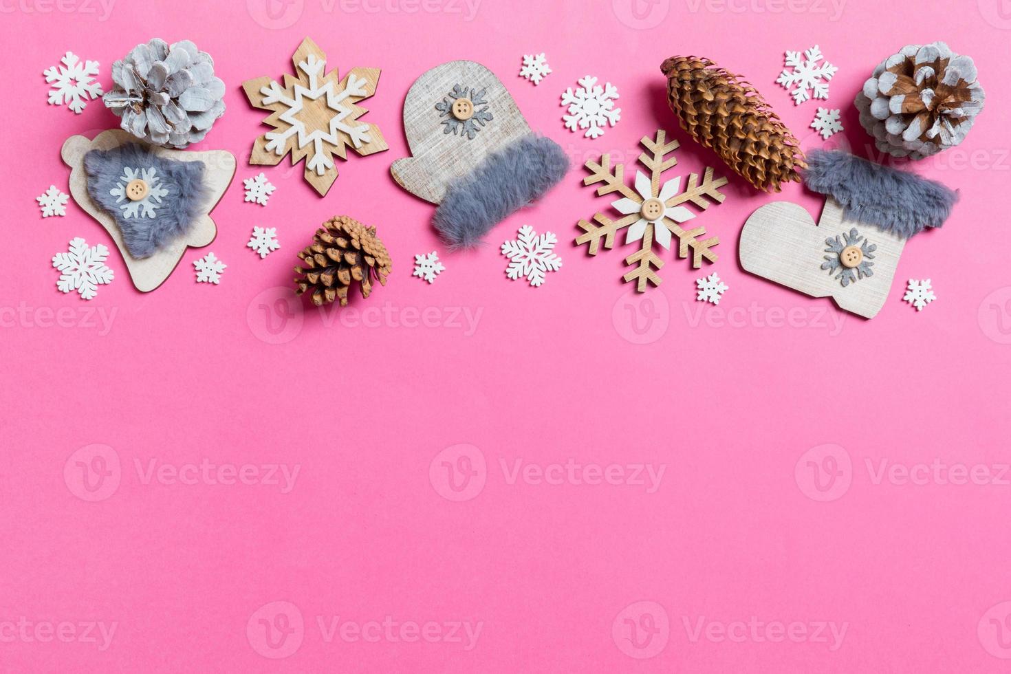 Top view of holiday toys and decorations on pink Christmas background. New Year time concept with copy space photo