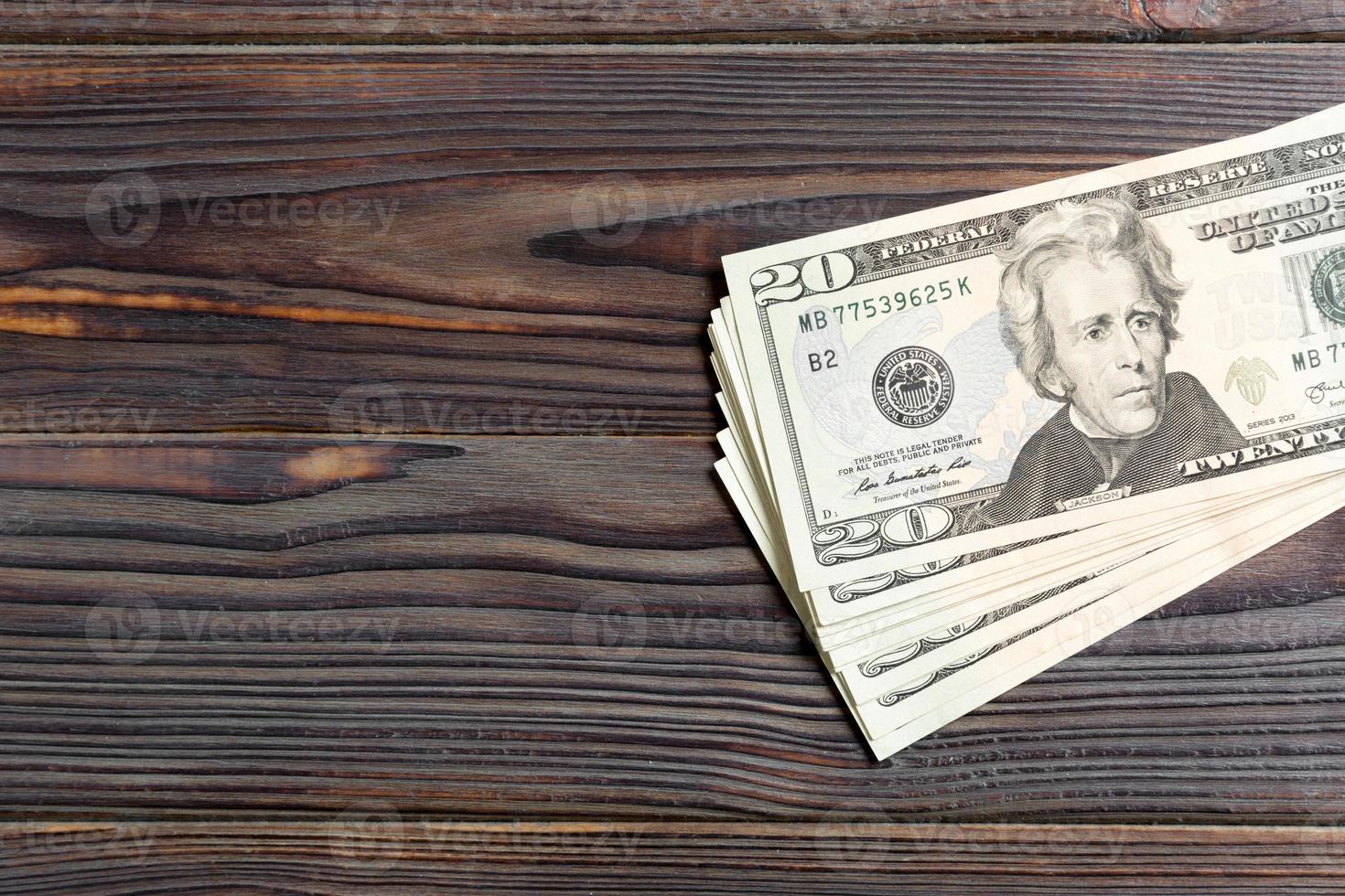 Top view of bundle of 20 dollar bill on wooden backgound. Business concept with copy space photo