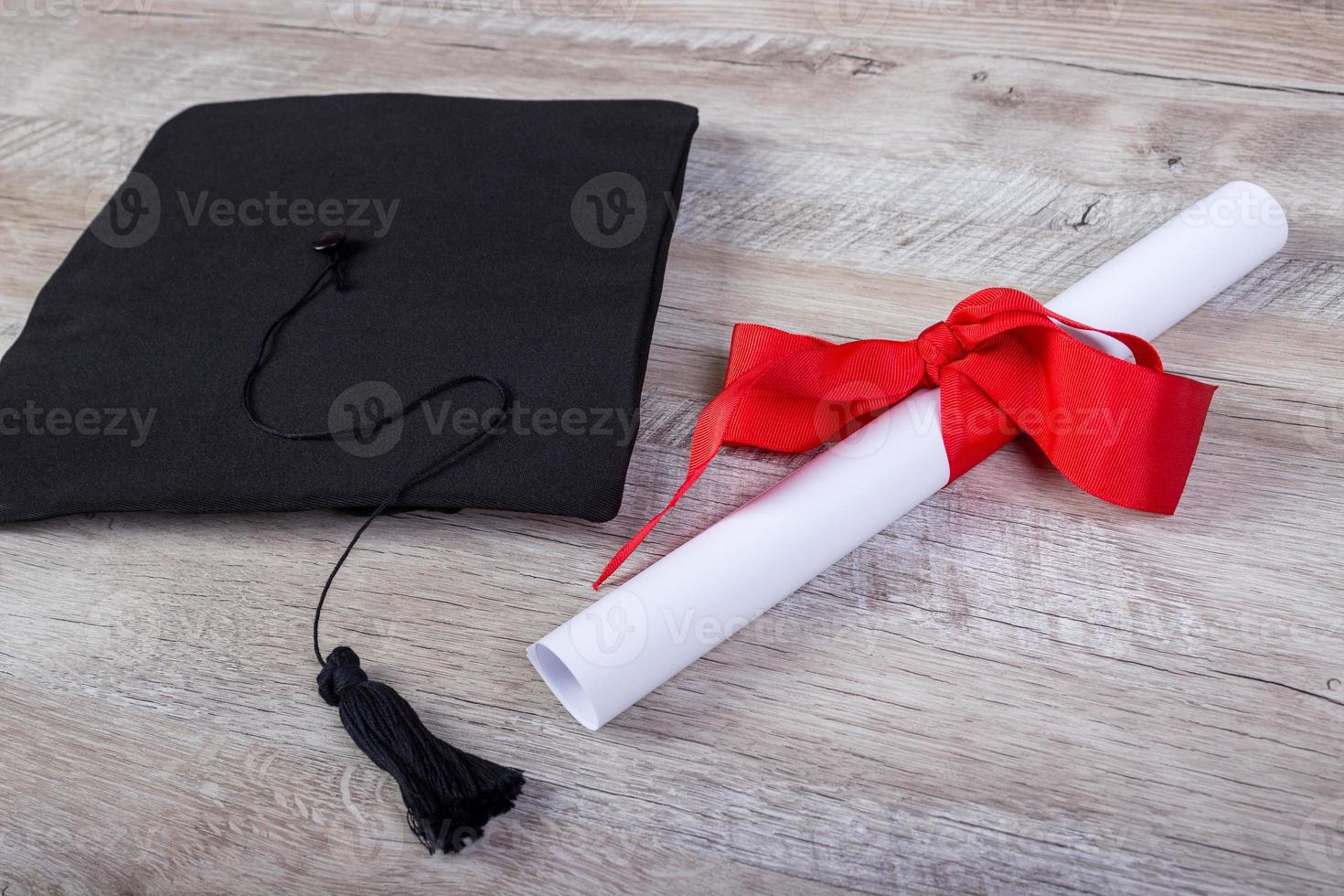 graduation cap, hat with degree paper on wood table graduation concept photo