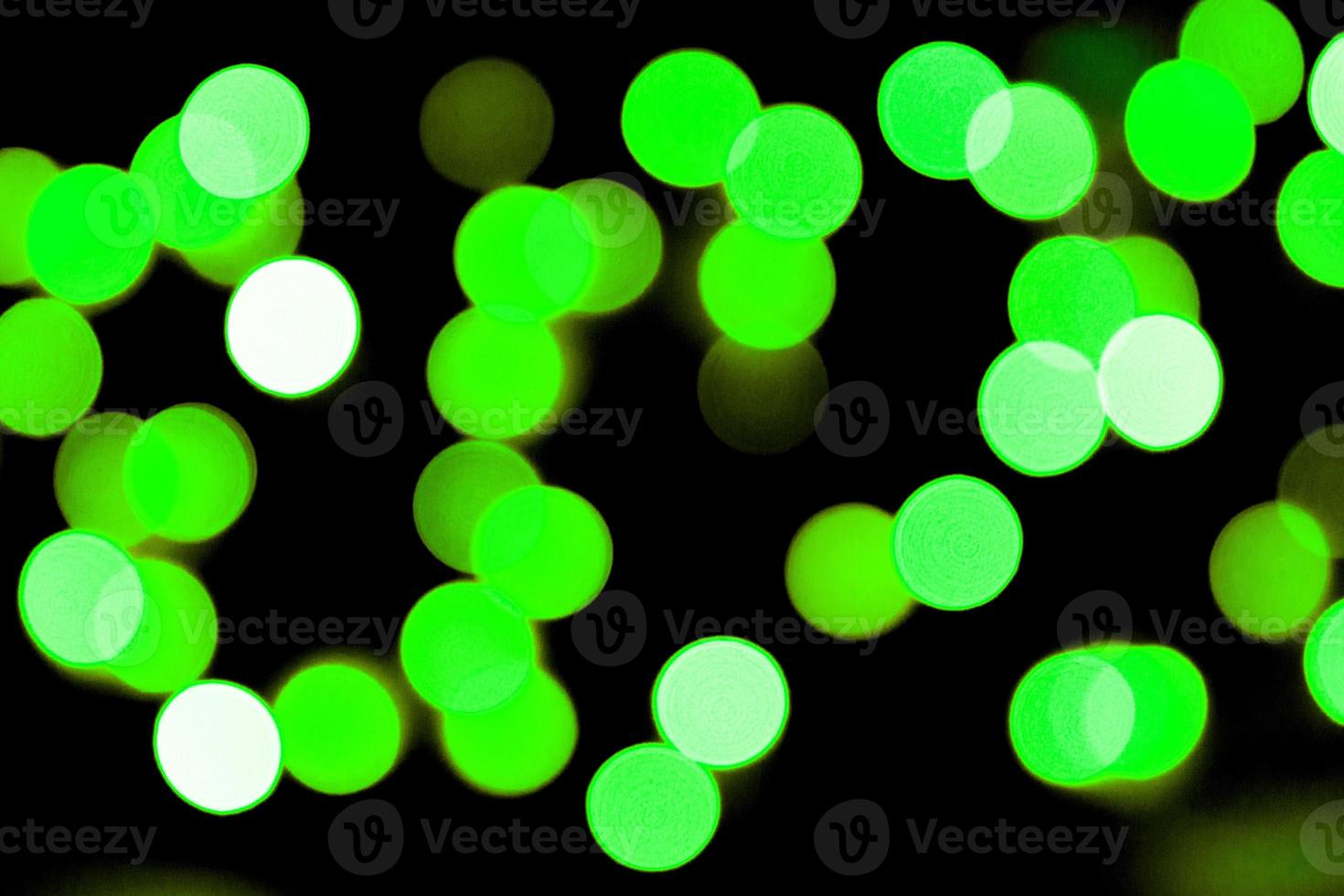 Unfocused abstract colourful bokeh black background. defocused and blurred many round green light photo