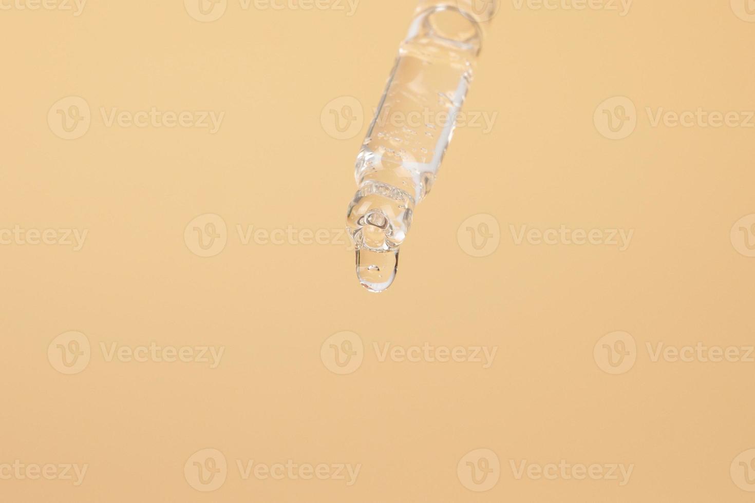 pipette with a drop essential oil on a yellow background photo