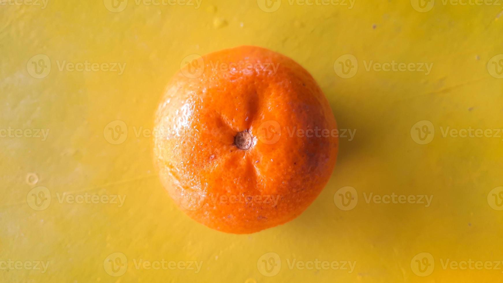 Top angle, Fresh orange fruit on a yellow background photo