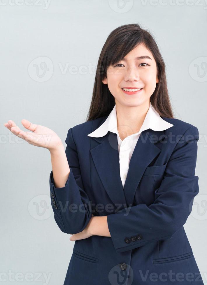 Asian woman in suit open hand palm gestures with empty space photo