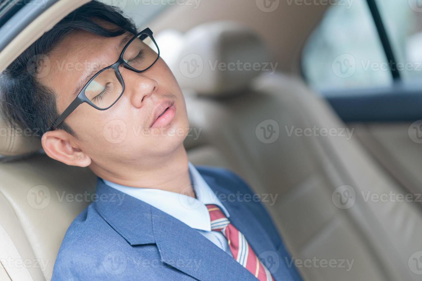 Businessman sit in the backseat of a car photo