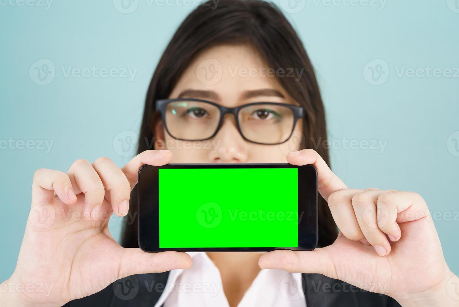 mujeres sosteniendo un teléfono inteligente simulado pantalla verde foto