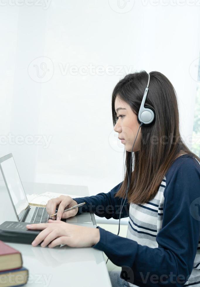 Young female long hair sitting in living room and learning online photo