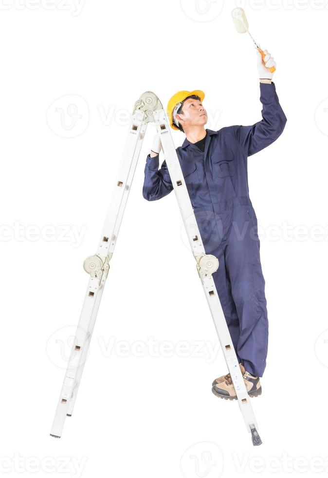 Handyman in uniform standing on ladder while using paint roller with clipping path photo