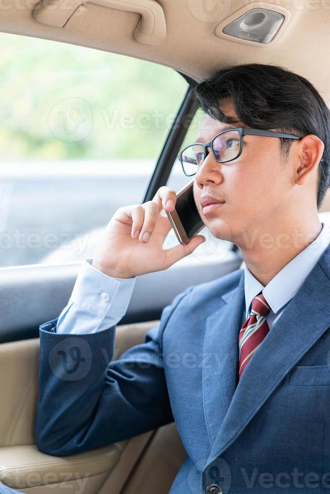 Businessman talking on the phone in car photo