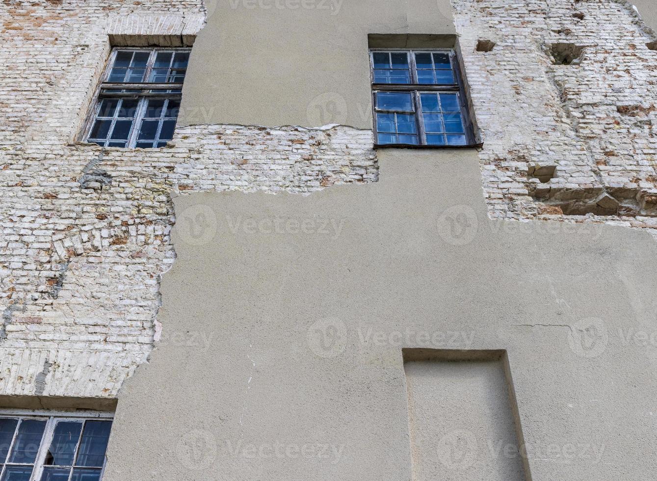 Part of the wall of an old building with damaged plaster photo