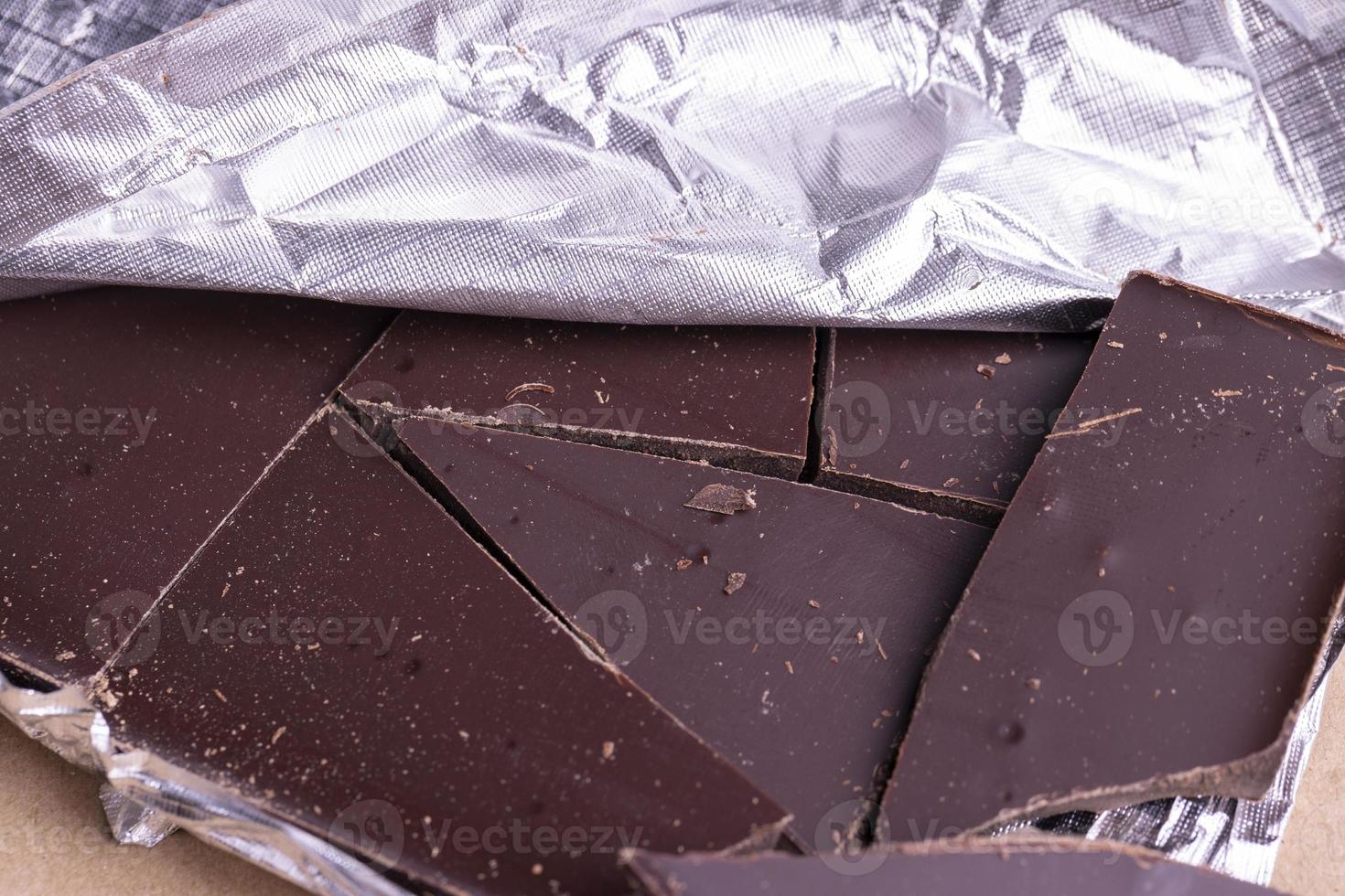 A broken chocolate bar in a paper and foil package photo