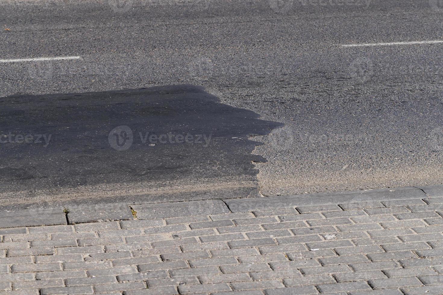 The repaired part of an asphalt road with patches photo