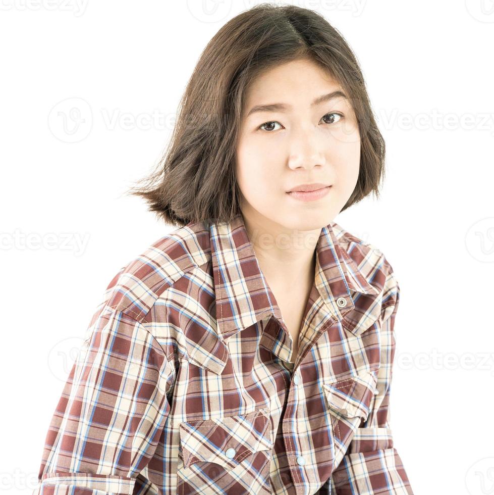 mujer joven en una camisa a cuadros posando en estudio en blanco foto