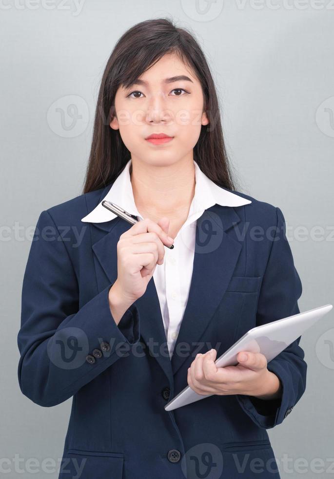 Woman in suit using computer digital tablet on gray photo