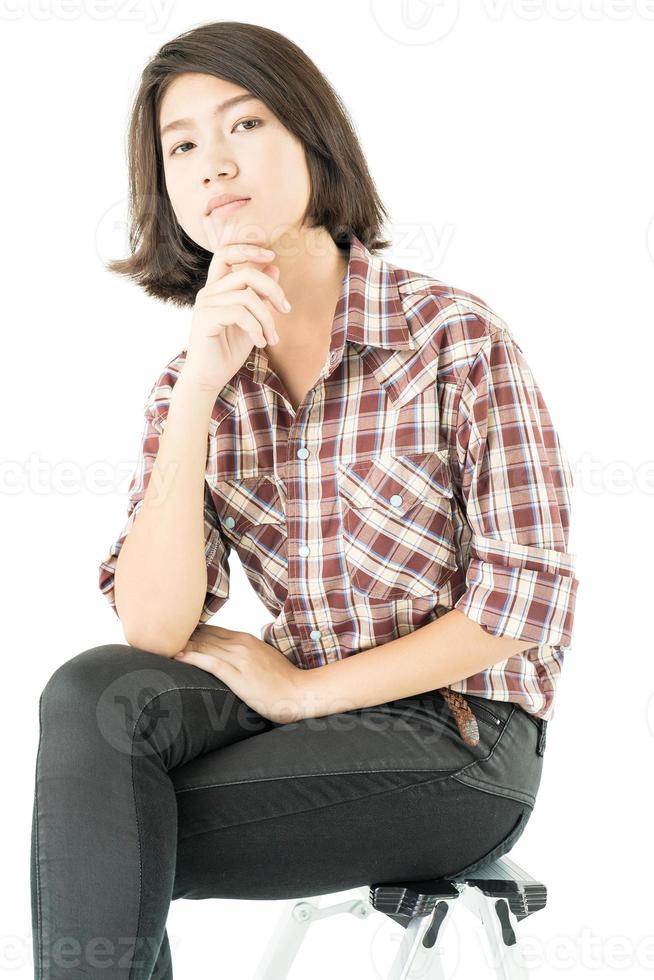 mujer joven en una camisa a cuadros posando en estudio en blanco foto